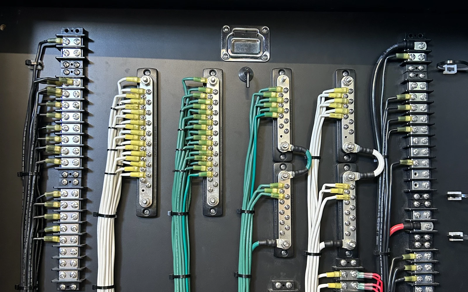 Rows of tinned bus bars and terminal strips organized inside a power distribution enclosure