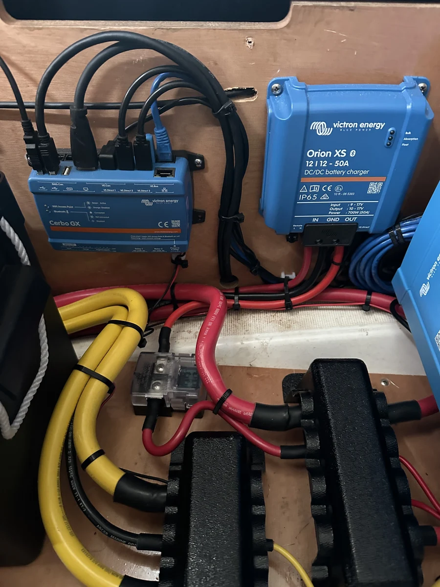 A Victron Cerbo GX monitor and Orion XS DC-DC charger wired into tinned bus bars