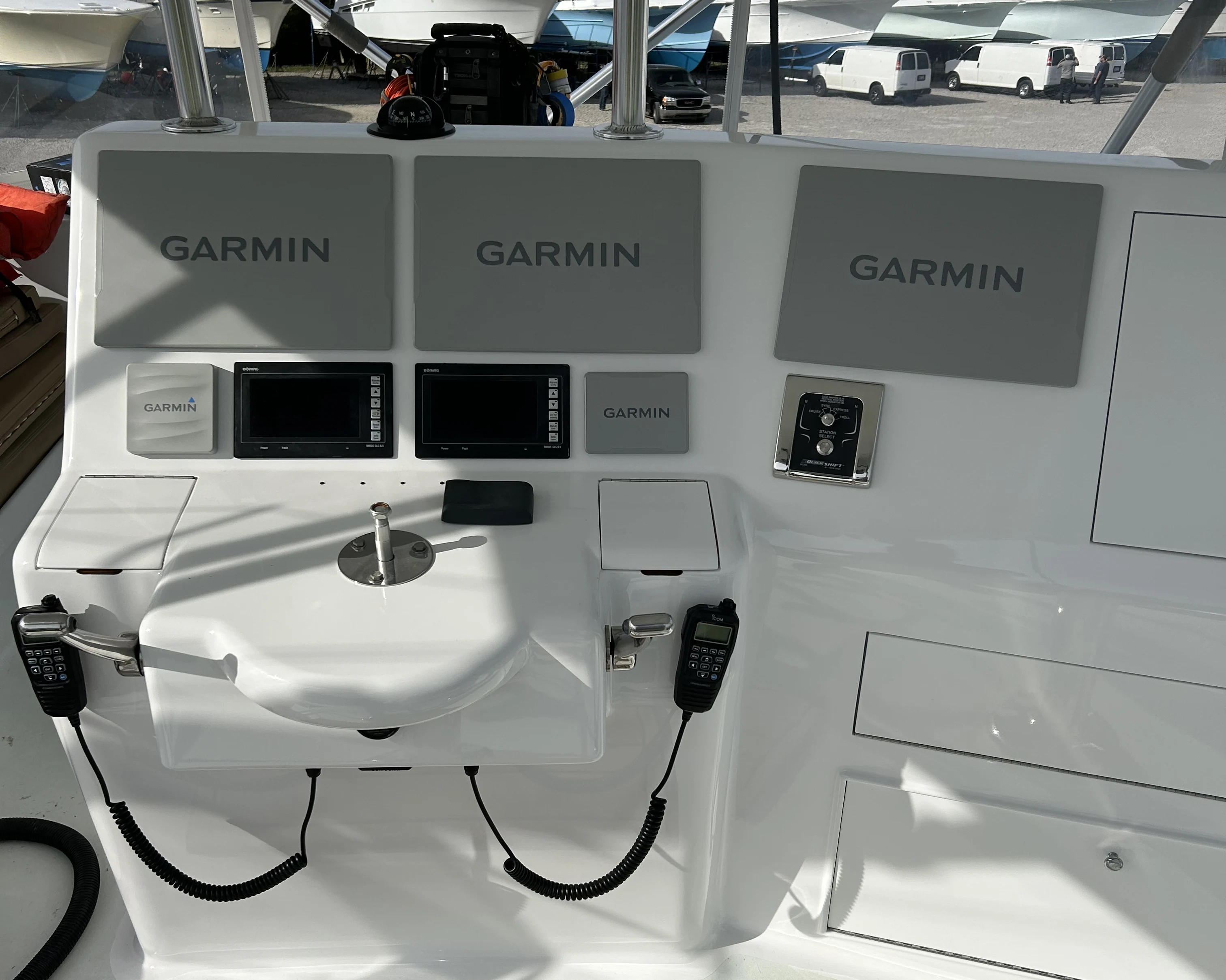A center console helm with three Garmin multifunction displays, VHF radios, and integrated electronics