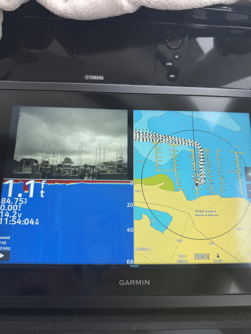 A Garmin multifunction display split-screen showing camera, sonar, and radar chart views