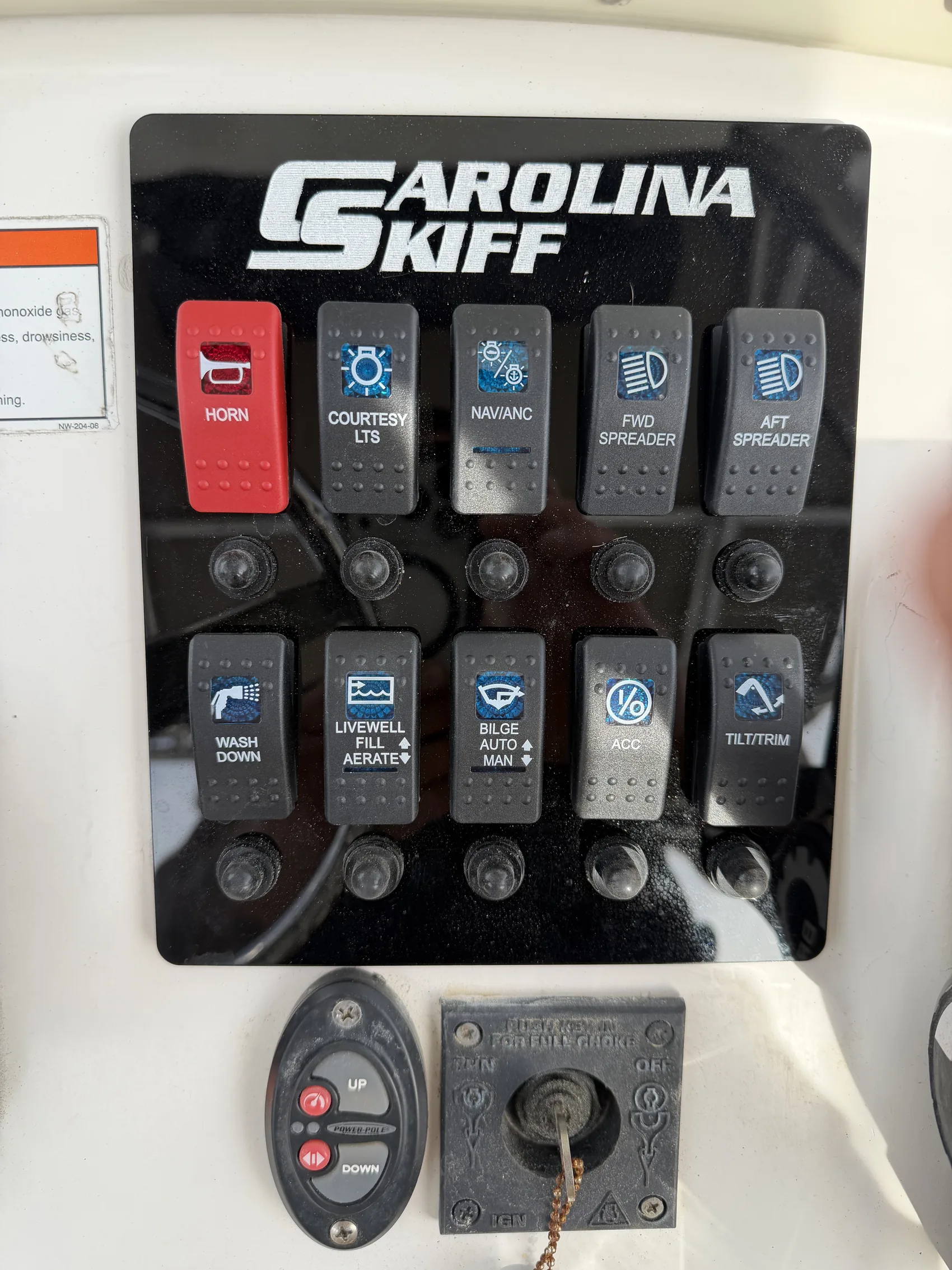 A center console's switch panel wired and labeled for spreader lights, bilge, livewell, and accessory circuits