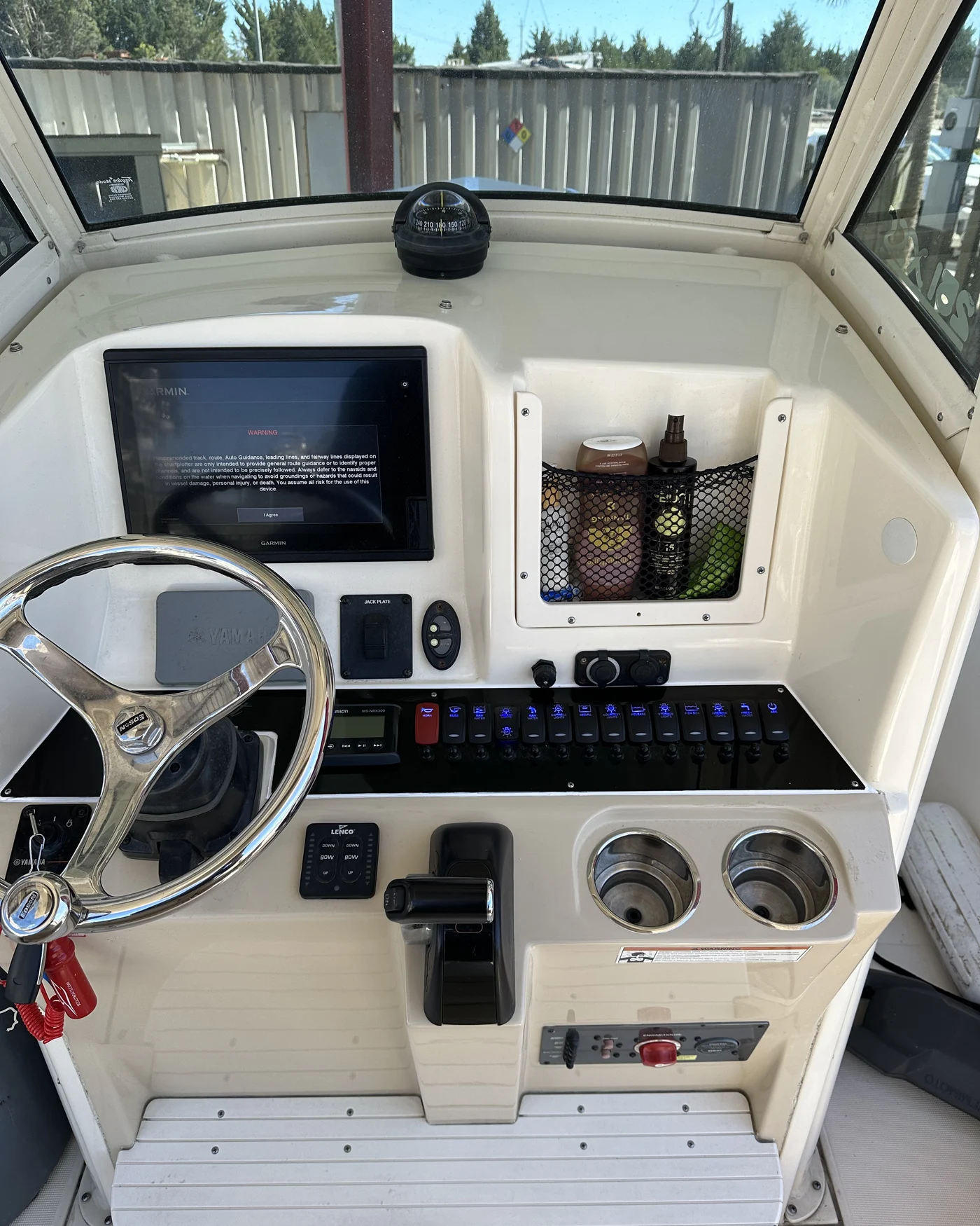 A center console helm with a Garmin multifunction display, switch panel, and VHF freshly wired in