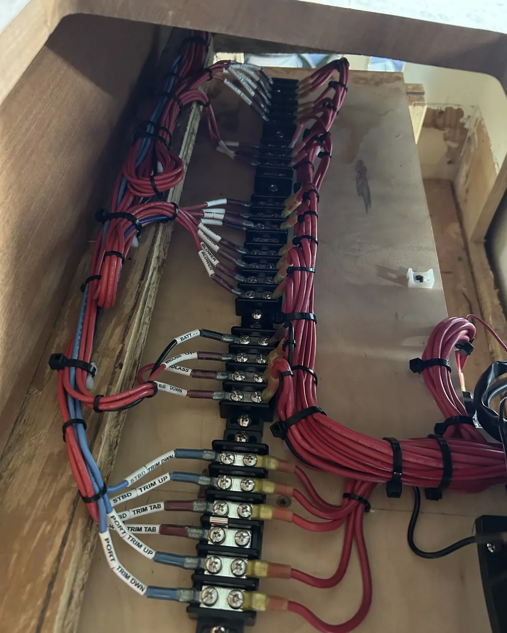 Individual circuits landed on a terminal strip and labeled for trim tabs, windlass, blower, and horn