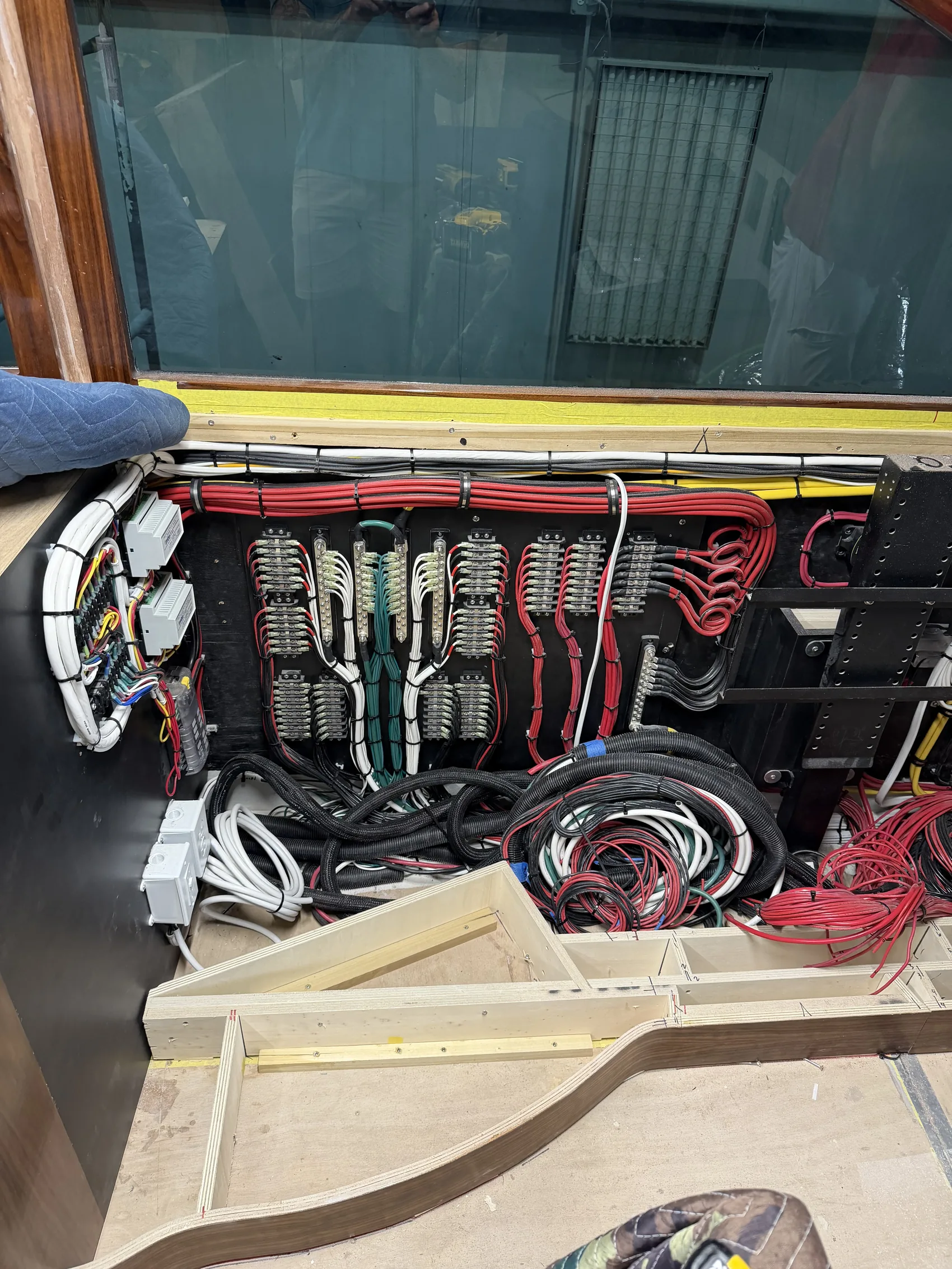 Organized wiring bundles run through a bulkhead during a vessel electrical refit